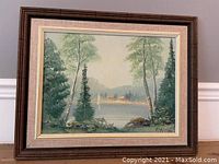 Framed oil on board showing overall lake and cottage scene with sailboats and trees, signed by artist