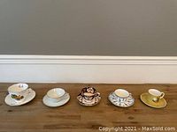 Overall view of all 5 tea cup and saucer sets in a row showing their size and pattern variety.