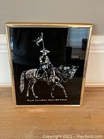 Front view of the framed artwork showing RCMP officer on horse with flag on black background