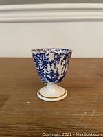Front side view of the Royal Crown Derby Mikado egg coddler showing the detailed blue oriental floral pattern on white porcelain with gold trim on base and rim.