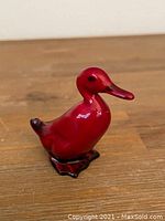 Front side view of the Royal Doulton flambe duck figurine showing glossy red glaze and detailed beak and feet