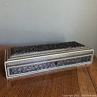 Full view of the rectangular carved wooden box showing foliage and animal motifs with micro mosaic edging on a wooden surface.