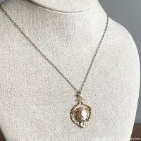 Necklace displayed on a bust form showing the chain length and cameo pendant.