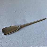 Full length view of Birks sterling silver letter opener, showing the pointed letter opening blade and engraved handle.