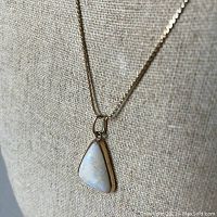 Gold chain necklace draped on a display bust showing full 18-inch length and drape.