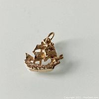 Front view of the 10K gold sailing boat charm showing detailed sails and boat structure.