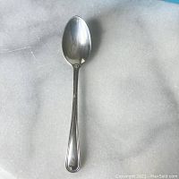 Top view of the sterling silver spoon on a marble surface.