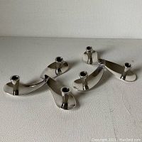 Pair of silver-plated propeller design candle holders laid flat showing overall shape and design