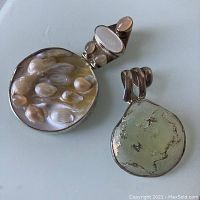 Front view of pendant showing blister pearls in mother of pearl and moonstone insets with hinged top portion