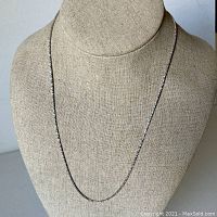 Full-length view of the necklace draped on a display bust
