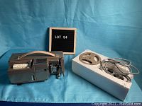 Vintage Magnon 800 8mm movie projector with original packaging and accessories including film reels and power cord.