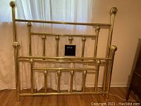 Full bed frame including headboard and footboard, showing brass finish with spherical finials and vertical bars with rounded ends.