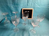 Six clear crystal wine glasses displayed on a blue background, showing overall style and quantity.