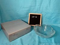 Glass wave pattern bowl next to box labeled Studio Nova, with lot number board