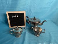 Full view of all three pieces in the Viking Silver Plate tea set against a blue background.