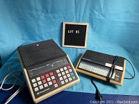 Two vintage Pitney Bowes postal scales next to a lot sign