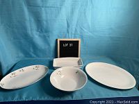 Full set of four white serving dishes: two oval platters with floral accent, one round matching bowl, and one plain rectangular serving dish.