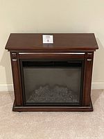 Front view of the portable electric fireplace unit with wood finish exterior, unlit.