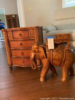 Both elephant table and bamboo-style chest shown side by side in family room