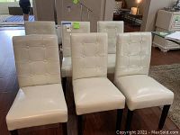 Six chairs arranged in dining area on hardwood floor
