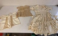 Photo showing all three antique dresses laid out on a table