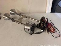 Side view of dual trumpet air horns and wiring on a table.