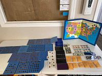 Overview of blue album pages, map board, proof and mint sets arranged on table