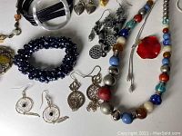 Close-up of assorted costume jewelry including bracelets, earrings, necklaces with beads and metal elements