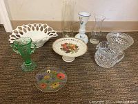 Full view of all glassware items in the lot on carpeted floor