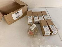 Photo showing six Keeprite Refrigerant Ball Valves boxed and one unpackaged valve on a white surface.