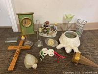 Photo showing the complete lot of assorted decorative collectibles including wooden crucifix, onyx turtle planter, clock, glass vases, theatrical masks, figurine sculpture, and cone-shaped item.