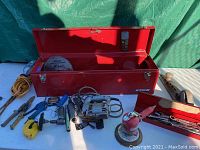 Front view of the open toolbox with tools laid out including a power tool and sanding equipment