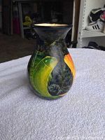 Front-left view of the 19th century Asian vase showing hand-painted green and orange koi fish on a dark glazed background.