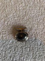 Front view of oval black stone pendant set in 925 sterling silver with large tubular bail.