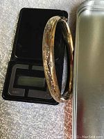 Bangle resting on digital scale showing weight