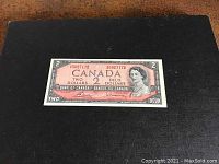 Front view of the 1954 Canadian Two Dollar banknote showing portrait of Queen Elizabeth II and serial number.