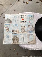 Front cover of Shaved Fish album showing illustrations and text related to Lennon and Plastic Ono Band.