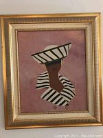Front view of framed canvas painting showing portrait of woman in striped hat and matching outfit