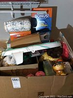 Box full of assorted baby and children's items including Huggies swim diapers in original packaging, toys, and baby accessories.