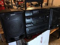 Wide shot showing the full Sony boom box with two detachable speakers, carrying handle, and multiple playback features.