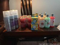 Full assortment of bath items on a dark wooden table including body wash bottles, Crayola bath slime tubs, Crayola bath bombs boxed, and Suave dry shampoo cans