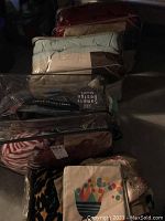 Image showing several bedding items including comforter sets and pillows packed in plastic bags plus a leopard print blanket visible.