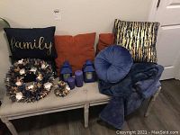 Photo showing the full set of pillows, blankets, lanterns, wreaths and candles arranged on a bench