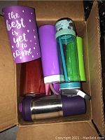 Tumbler and water bottles in box, assorted colors and sizes, some in purple and green