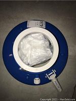 Top view of the blue and white pool leaf vacuum attachment showing the mesh bag inside and Pooline label on latch.