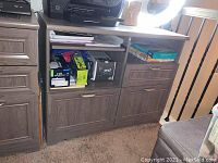 Front view of printer cabinet showing the open shelves with office supplies and three drawers.