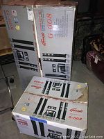 Two large boxes featuring the Genesis Media Labs G-608 surround sound system in original packaging with images of the speakers and components.