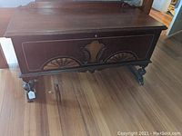 Front view of the full cedar chest showing the carved decorative panels and the lid with lock