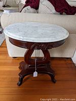 Front view showing marble top and harp-style wooden base