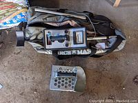 Search Master metal detector with carrying bag and sand scoop on ground.
